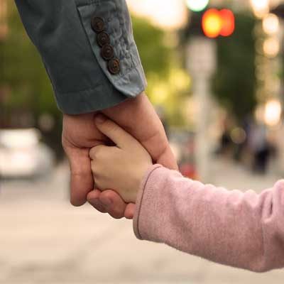 Little girl's hand holding an adult hand. Representing Attachment